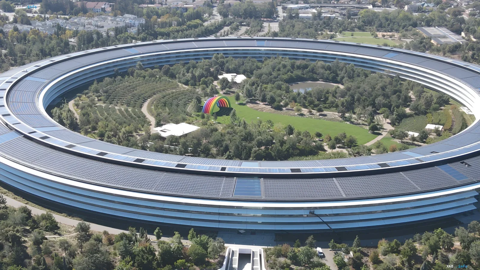 Luftaufnahme des Apple Park-Hauptquartiers mit einem Regenbogen-Kunstobjekt im Zentrum, das die Innovationen von Apple und den bevorstehenden Mangel an MacBook Air mit M5 symbolisiert